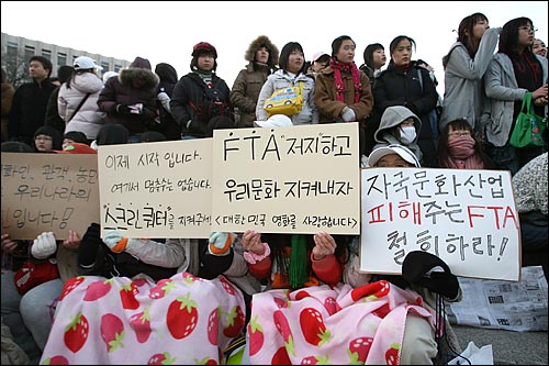 담요를 무릎에 덮은 여학생들이 스크린쿼터 사수 구호가 적힌 피켓을 들고 있다. 